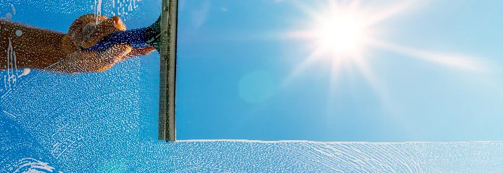Hand reinigt Fenster mit Abzieher